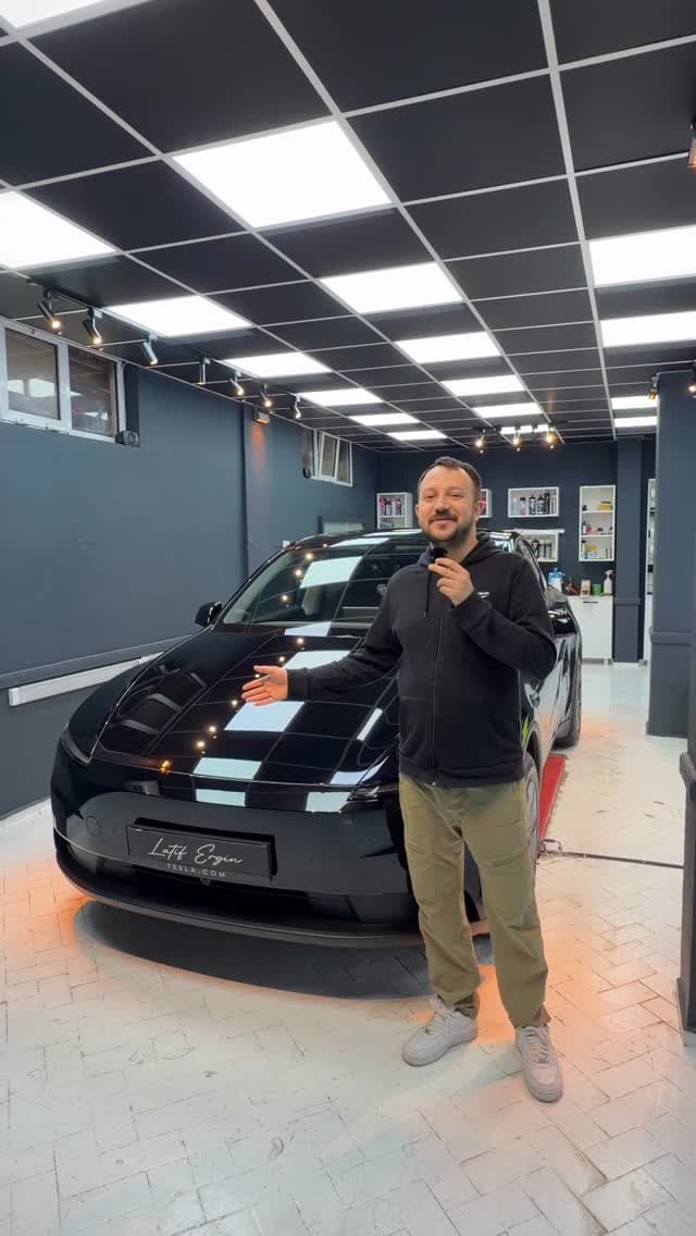 Latif Ergin, atölyede kaplaması tamamlanmış siyah otomobilin yanında